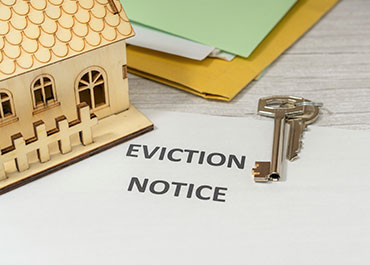 Eviction notice with a house model, symbolizing need to evict a tenant