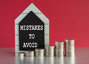 House shape with 'Mistakes to Avoid' text beside stacked coins on a red background